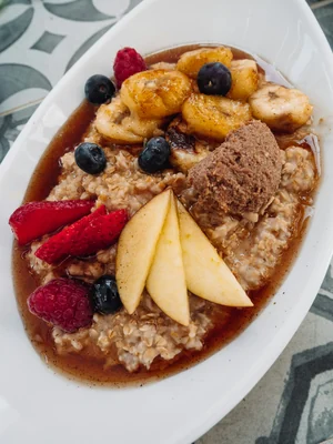 Mingau de aveia com banana, pera e frutas vermelhas